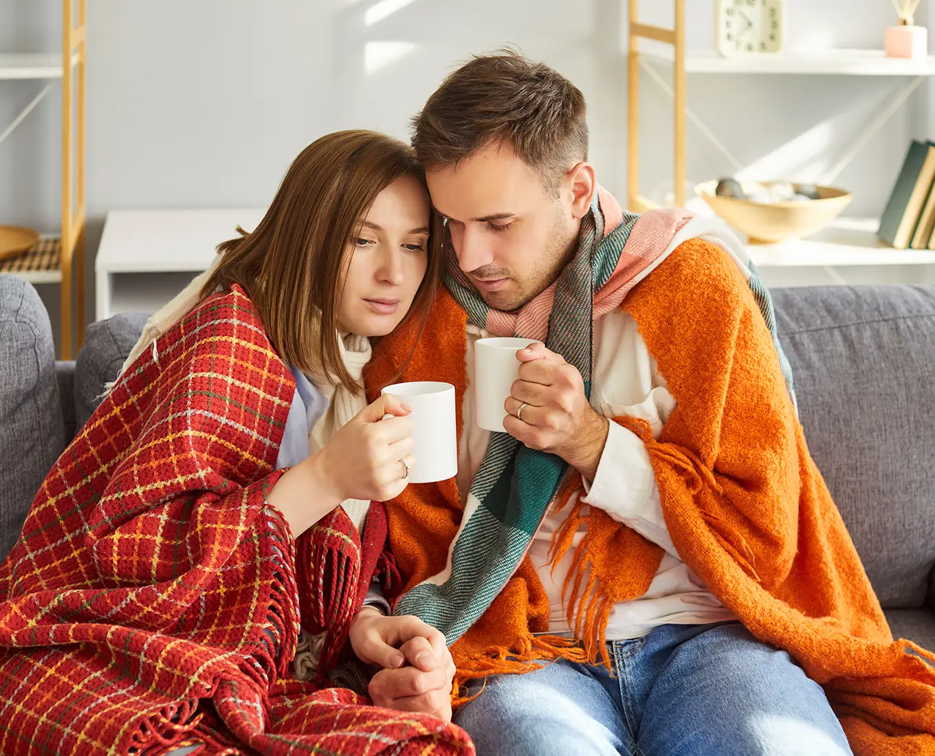 Farmington, MO couple bundling up under blankets due to broken heating system. They require reliable heating repair service.